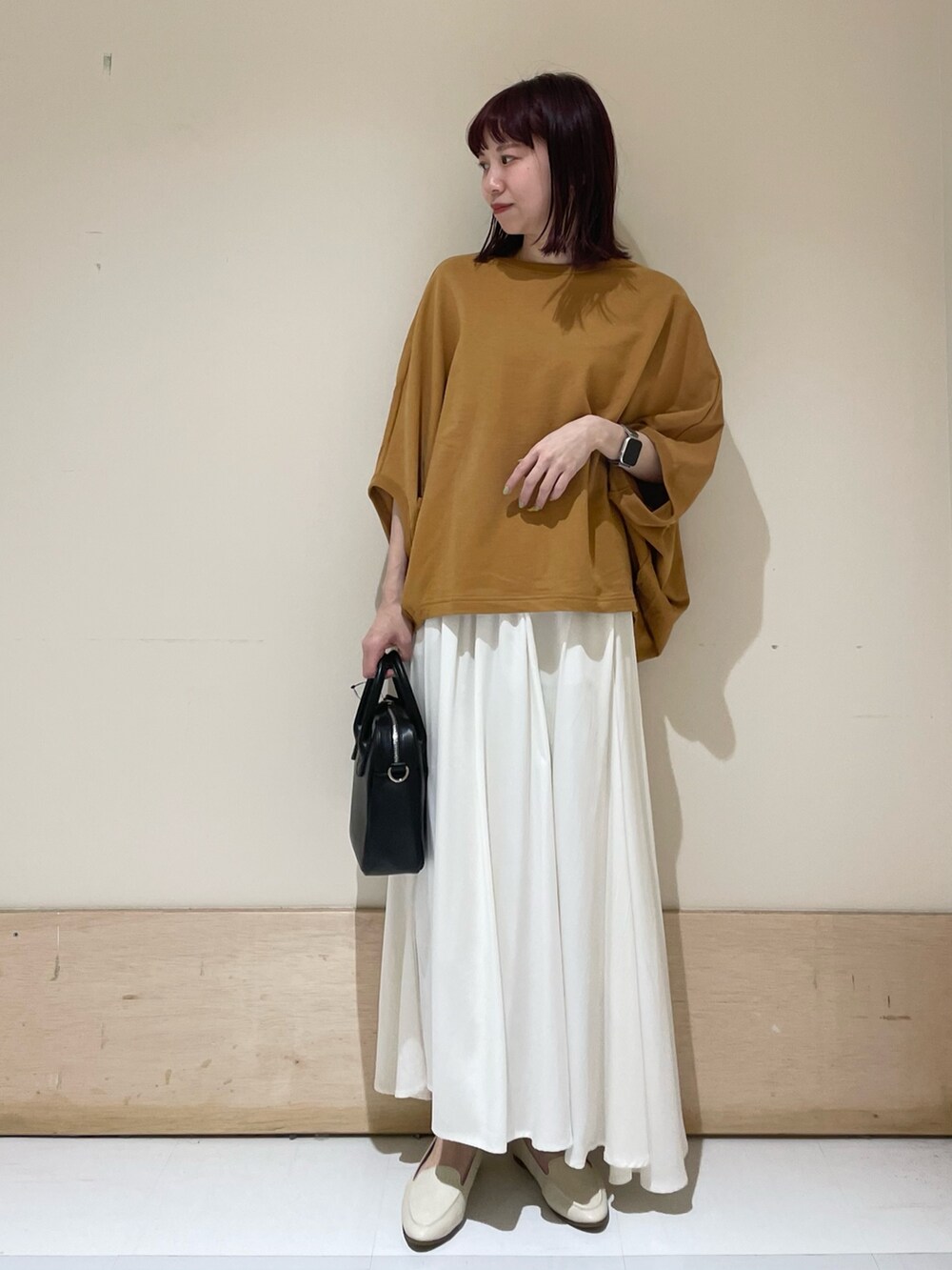 ホワイト系のスカート、イエロー系のTシャツ/カットソー、ブラック系のショルダーバッグを着用したレディースの春コーディネートの3枚目の写真