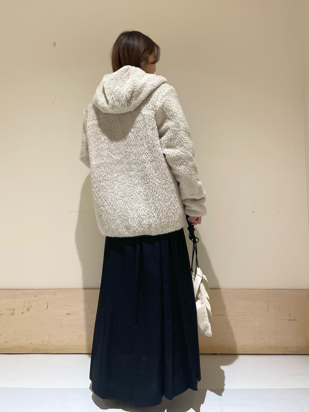 シルバー系のパンプス、ブルー系のTシャツ/カットソー、ベージュ系のハンドバッグを着用したレディースの秋コーディネートの8枚目の写真