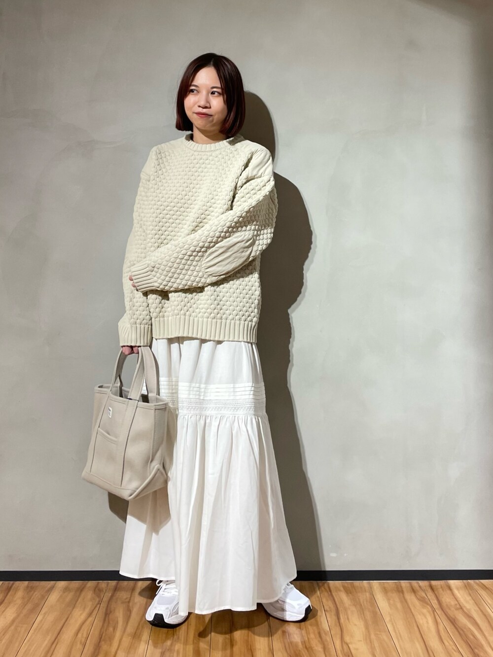 ベージュ系のニット/セーター、ホワイト系のスカートを着用したレディースの秋コーディネートの3枚目の写真