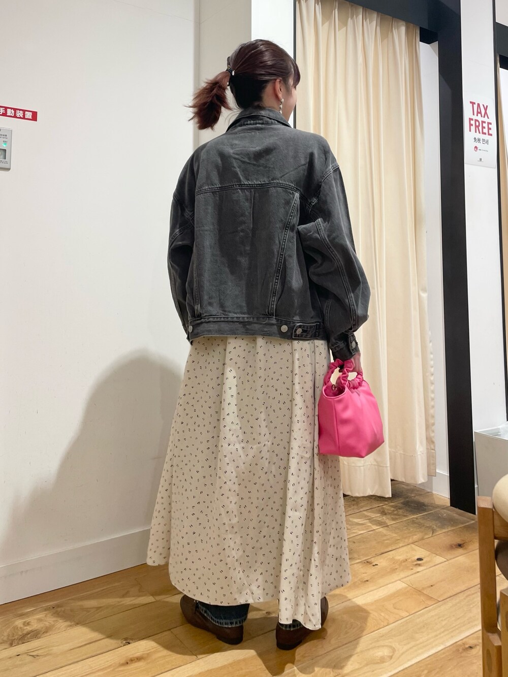 ブラック系のデニムジャケット、ブルー系のデニムパンツを着用したレディースの春コーディネートの5枚目の写真