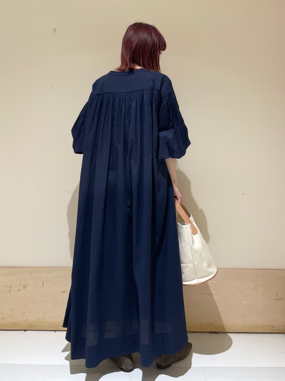 ホワイト系のトートバッグ、ブルー系のワンピース、ブラウン系のパンプスを着用したレディースの春コーディネートの7枚目の写真