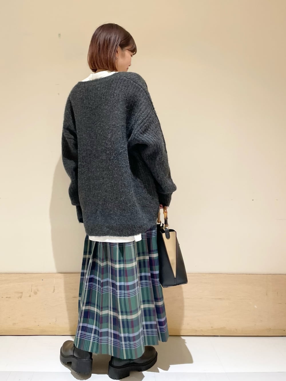 ホワイト系のシャツ/ブラウス、ブラック系のカーディガン/ボレロ、ブラック系のブーツを着用したレディースの秋コーディネートの6枚目の写真