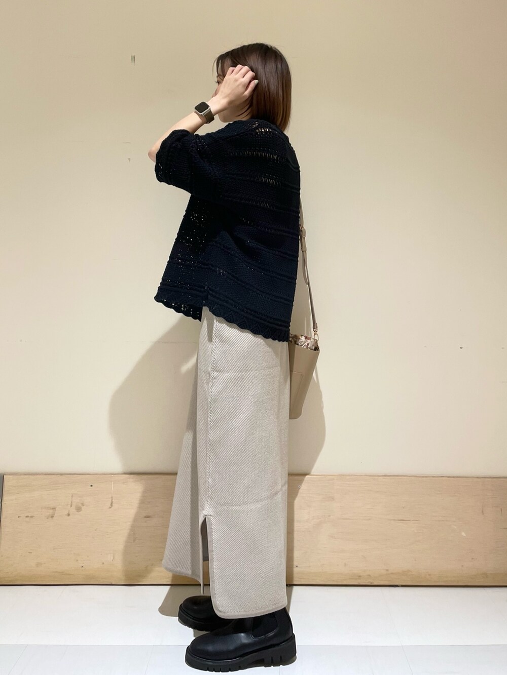 ベージュ系のショルダーバッグ、ブラック系のブーツ、ブラック系のニット/セーターを着用したレディースの秋コーディネートの5枚目の写真