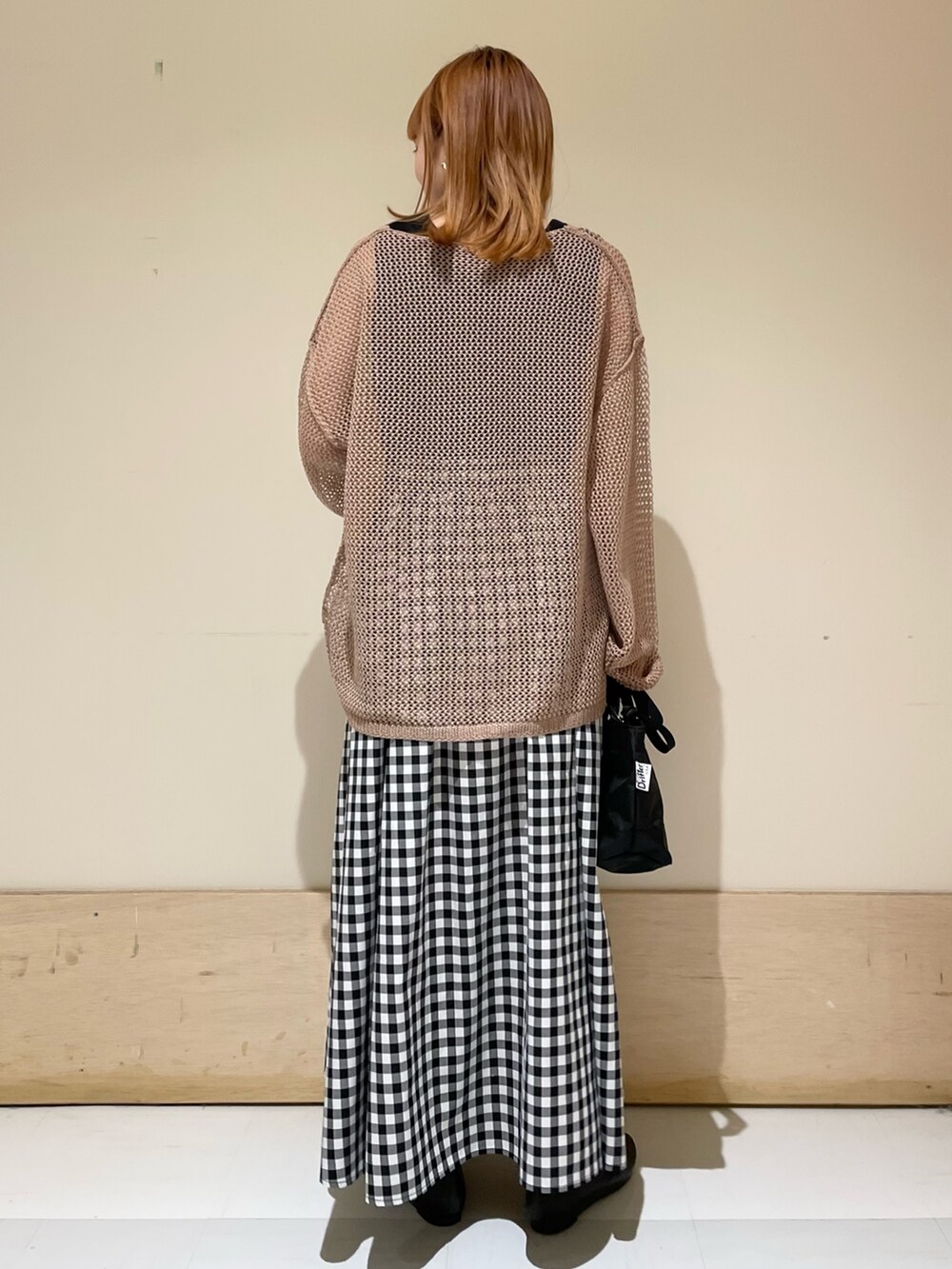 ブラウン系のカーディガン/ボレロ、ブラック系のタンクトップ、ブラック系のショルダーバッグを着用したレディースの春コーディネートの6枚目の写真