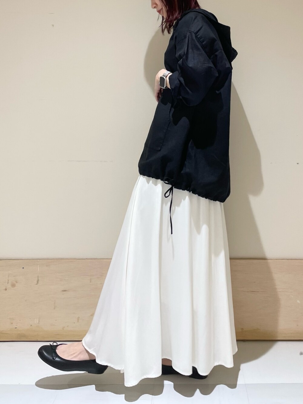 ブラック系のパーカー、ブラック系のバレエシューズ、ホワイト系のスカートを着用したレディースの春コーディネートの3枚目の写真