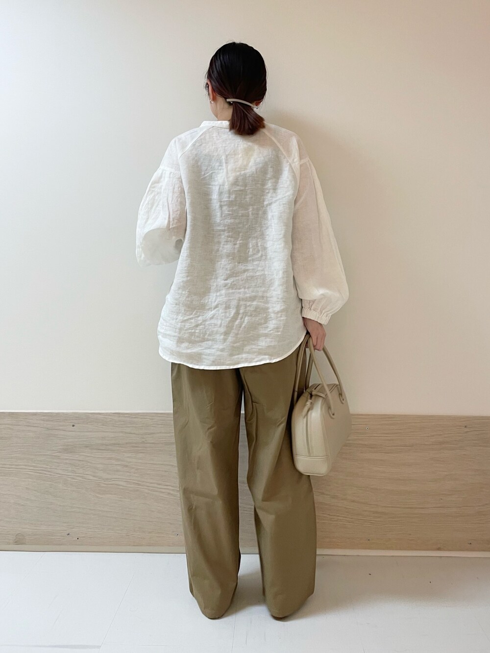ホワイト系のシャツ/ブラウス、ベージュ系のボストンバッグ、ベージュ系のその他パンツを着用したレディースの春コーディネートの8枚目の写真