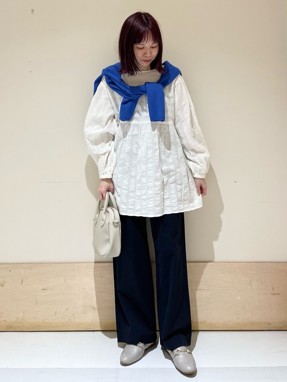 ブルー系のその他パンツ、ホワイト系のシャツ/ブラウス、ブルー系のニット/セーターを着用したレディースの春コーディネートの2枚目の写真