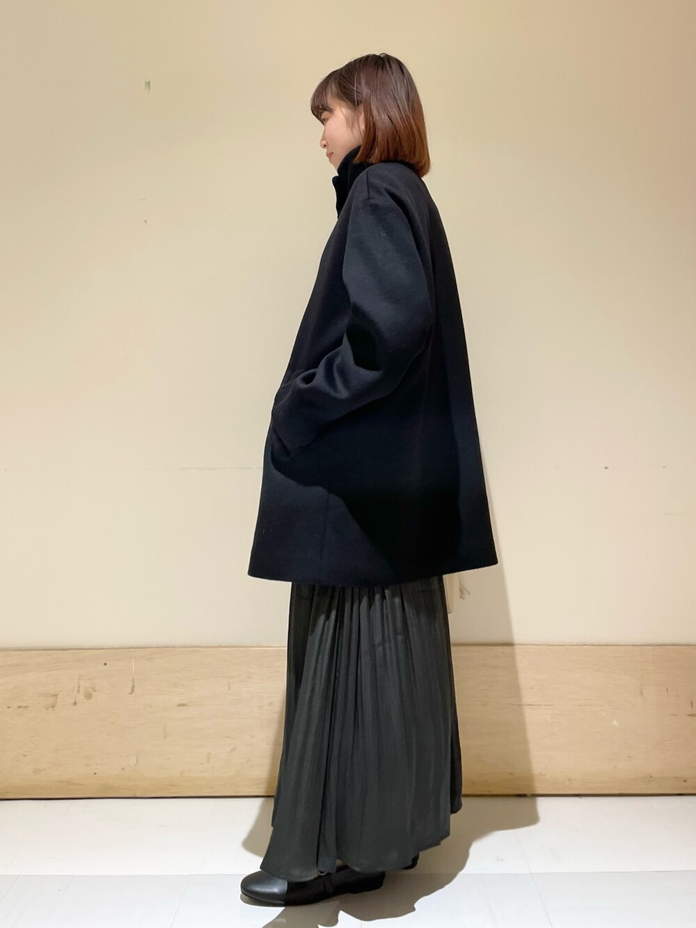 グリーン系のスカート、グレー系のニット/セーター、ブラック系のその他アウターを着用したレディースの冬コーディネートの5枚目の写真