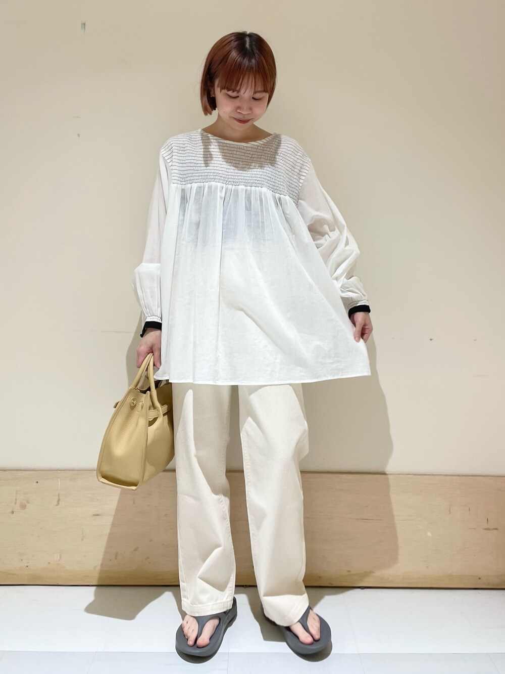 グレー系のサンダル、イエロー系のトートバッグ、ホワイト系のシャツ/ブラウスを着用したレディースの春コーディネートの2枚目の写真