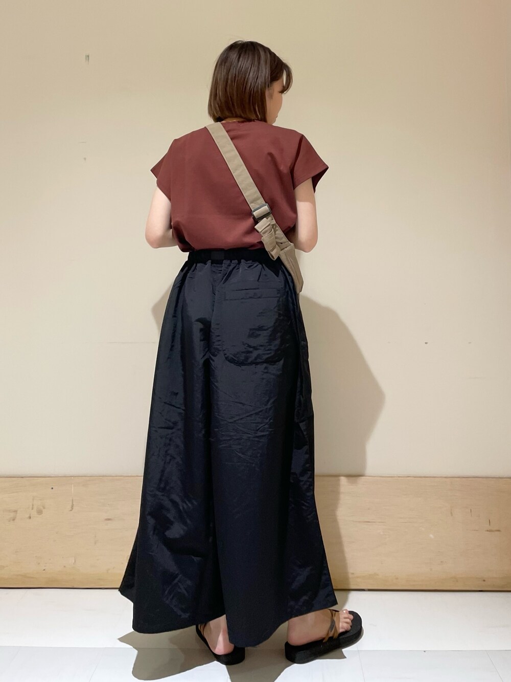 レッド系のTシャツ/カットソー、オレンジ系のサンダル、ベージュ系のショルダーバッグを着用したレディースの夏コーディネートの6枚目の写真