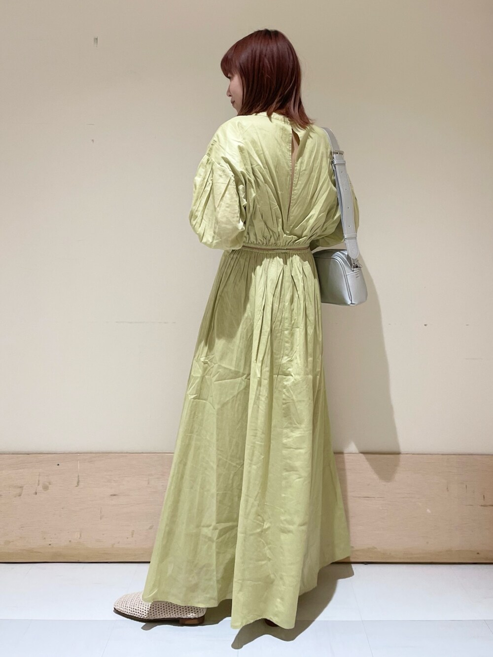 グリーン系のワンピース、シルバー系のショルダーバッグ、ホワイト系のパンプスを着用したレディースの春コーディネートの7枚目の写真