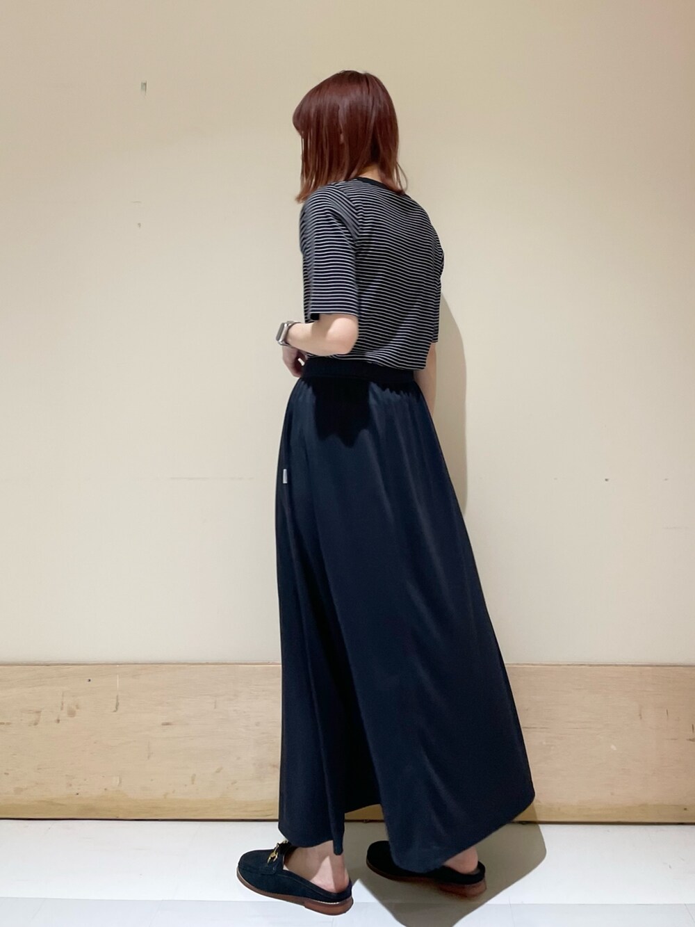 ブルー系のその他シューズ、ブルー系のスカート、ブラック系のハンドバッグを着用したレディースの春コーディネートの5枚目の写真