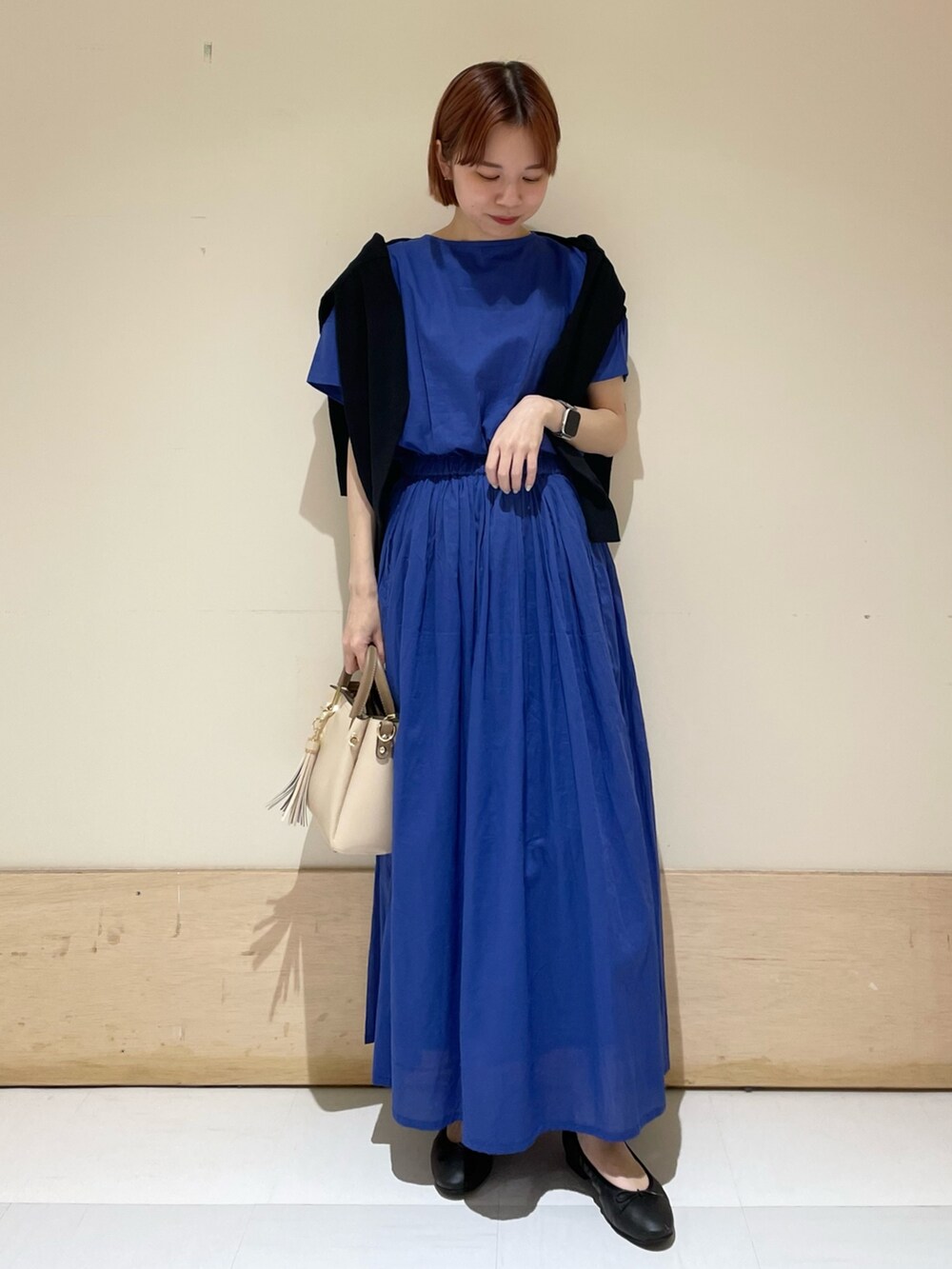 ブルー系のワンピース、ブラック系のカーディガン/ボレロ、ホワイト系のトートバッグを着用したレディースの春コーディネートの4枚目の写真