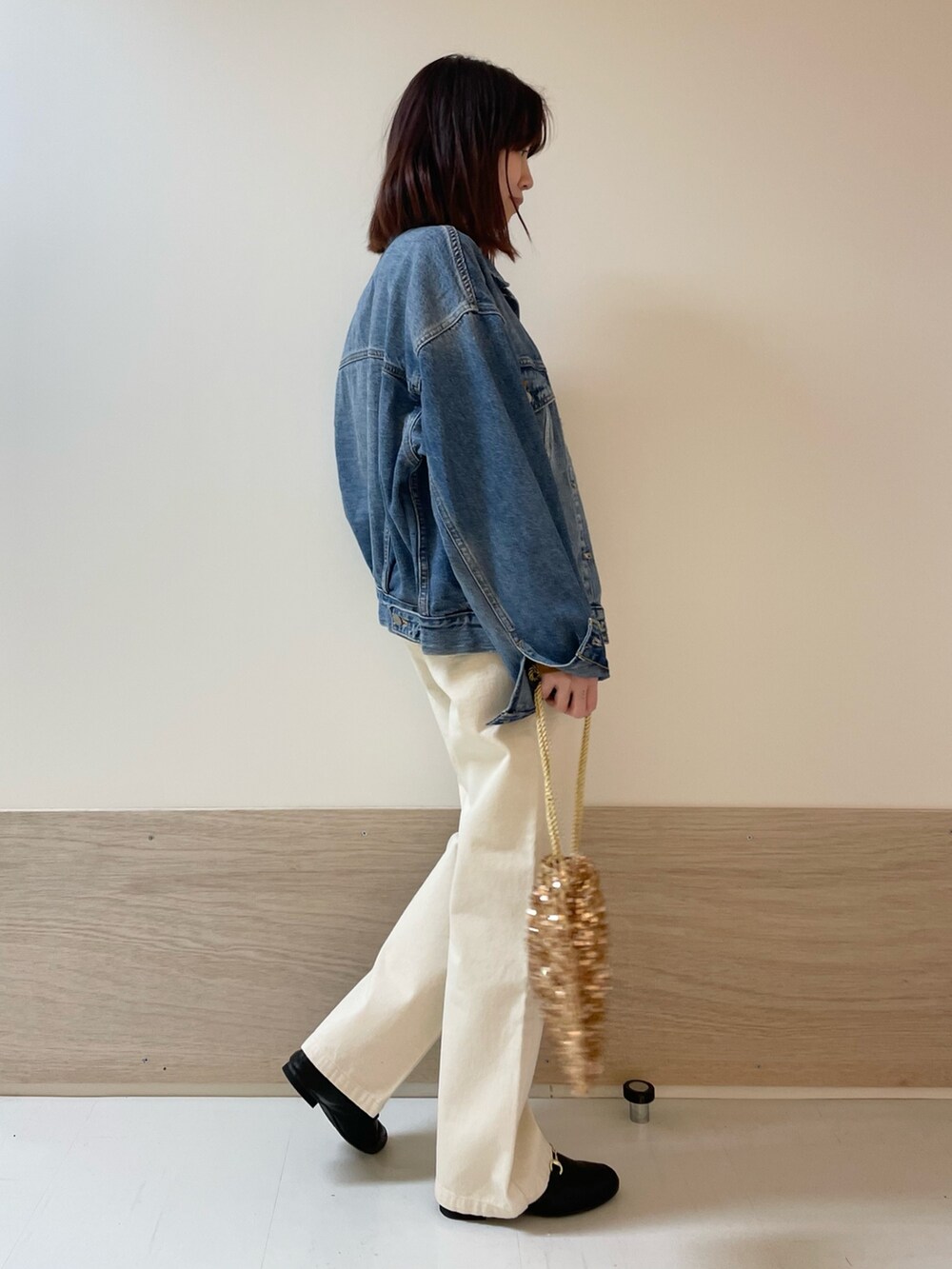 イエロー系のニット/セーター、ベージュ系のデニムパンツ、ブルー系のデニムジャケットを着用したレディースの冬コーディネートの4枚目の写真