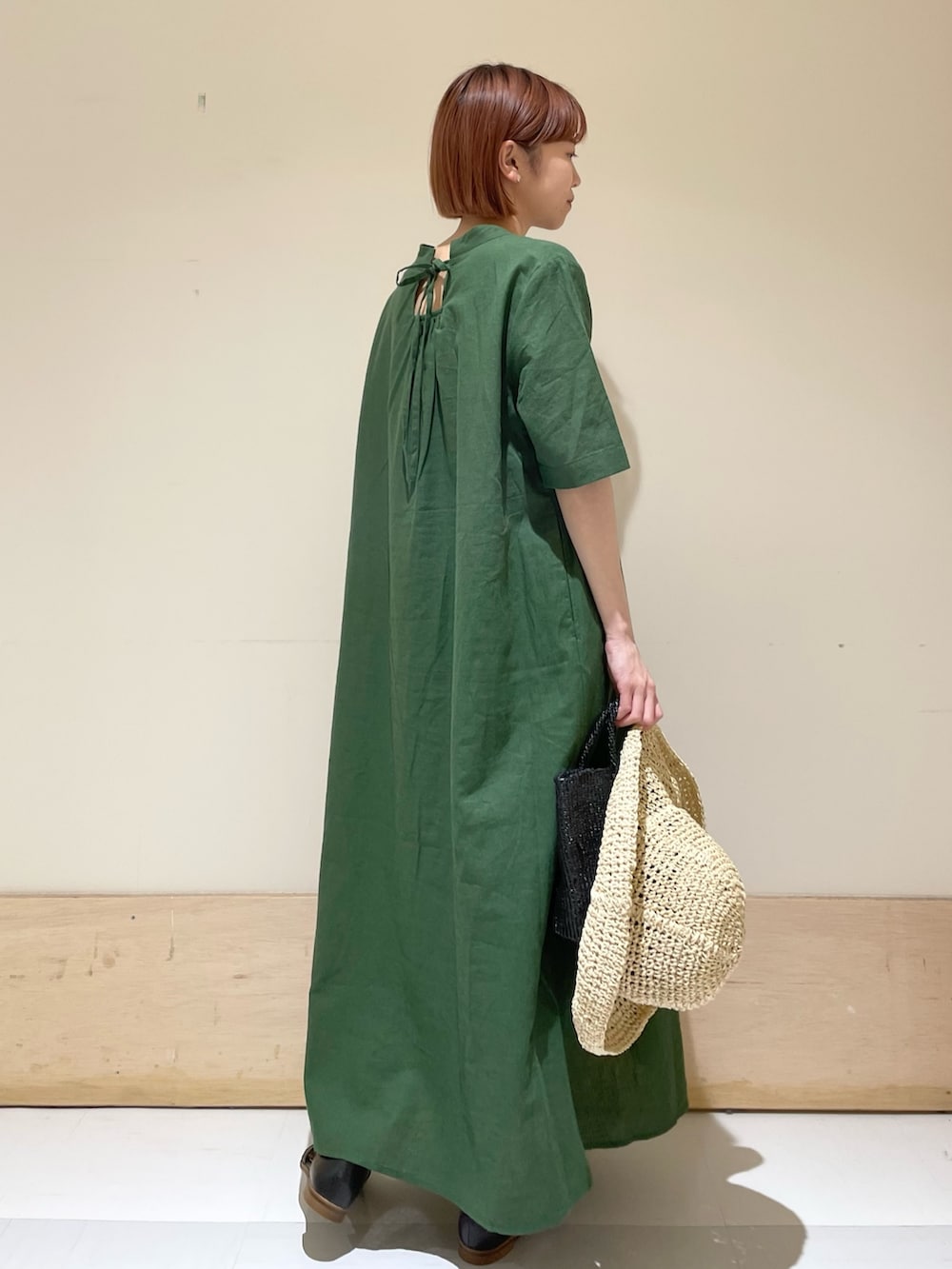 グリーン系のワンピース、ブラック系のサンダル、ブラック系のハンドバッグを着用したレディースの春コーディネートの7枚目の写真