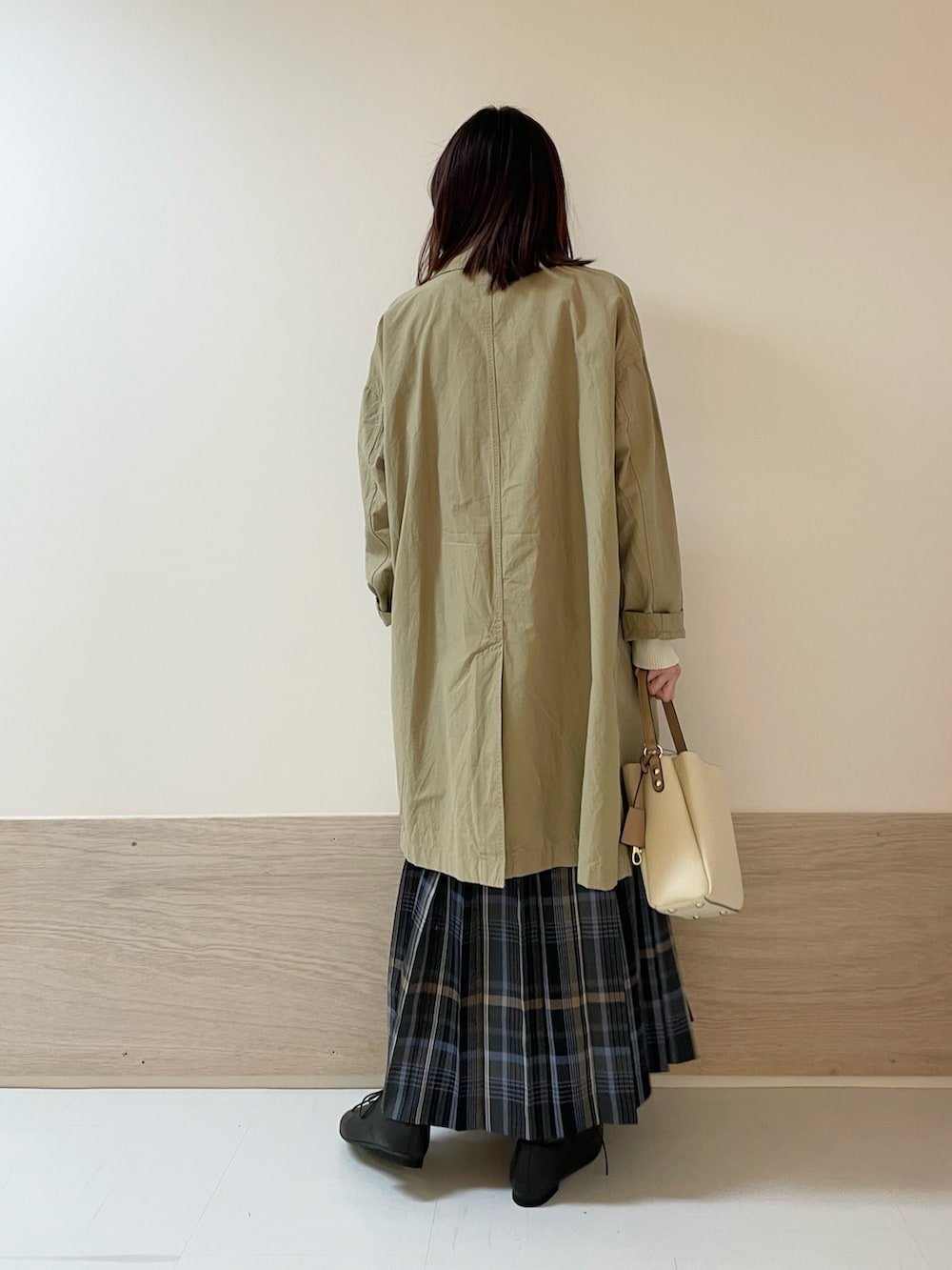 グレー系のスカート、ホワイト系のニット/セーター、ベージュ系のその他アウターを着用したレディースの春コーディネートの9枚目の写真