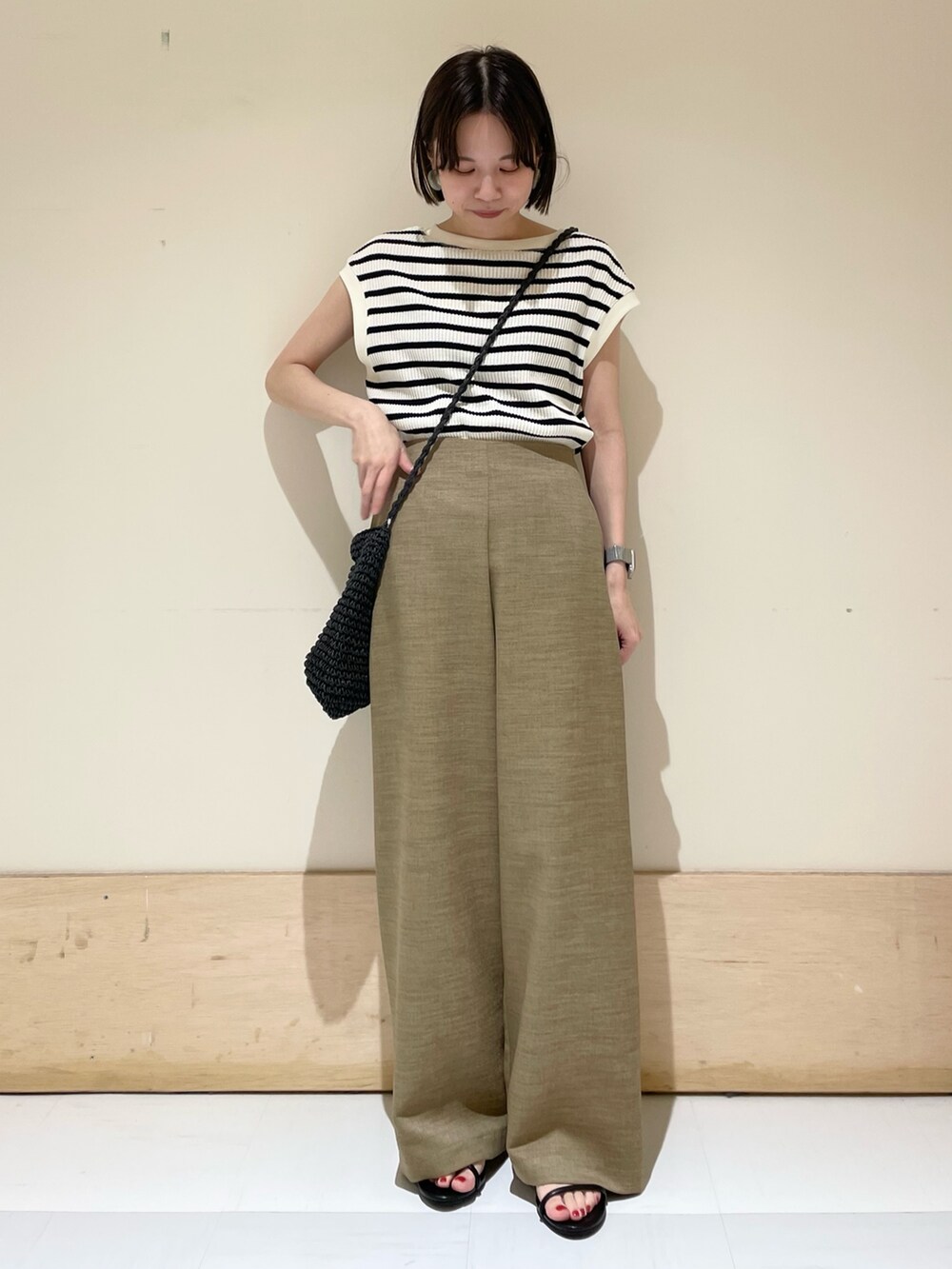 ベージュ系のその他パンツ、ブラック系のショルダーバッグ、ホワイト系のTシャツ/カットソーを着用したレディースの夏コーディネートの2枚目の写真