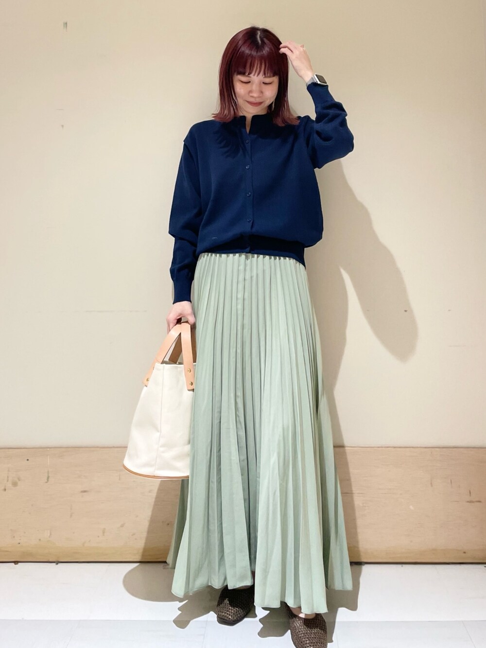 ブルー系のカーディガン/ボレロ、ブラウン系のパンプス、ホワイト系のトートバッグを着用したレディースの春コーディネートの3枚目の写真