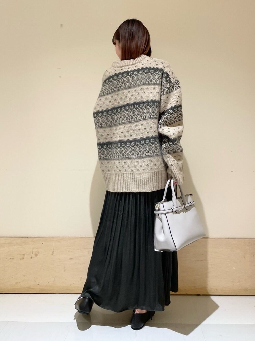 ベージュ系のニット/セーター、グレー系のスカート、ブラック系のその他シューズを着用したレディースの冬コーディネートの7枚目の写真