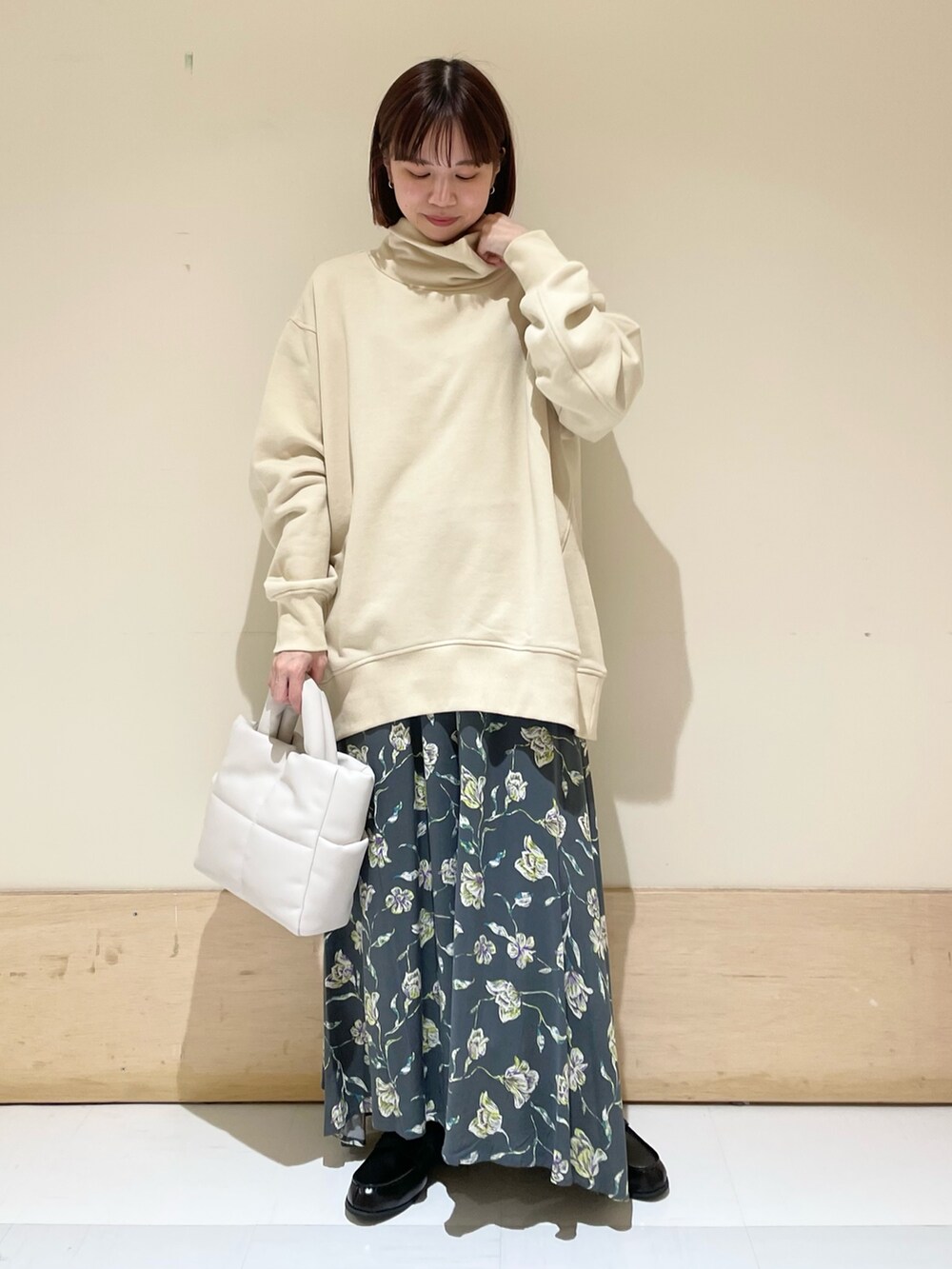 ベージュ系のスウェット、グレー系のスカート、ホワイト系のトートバッグを着用したレディースの秋コーディネートの3枚目の写真