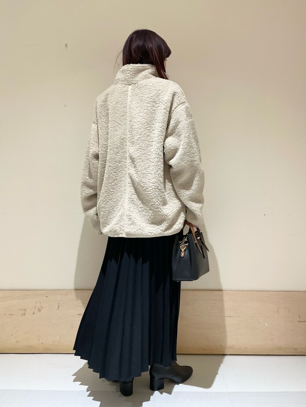 ピンク系のニット/セーター、ホワイト系のブルゾン、ブラック系のスカートを着用したレディースの冬コーディネートの7枚目の写真