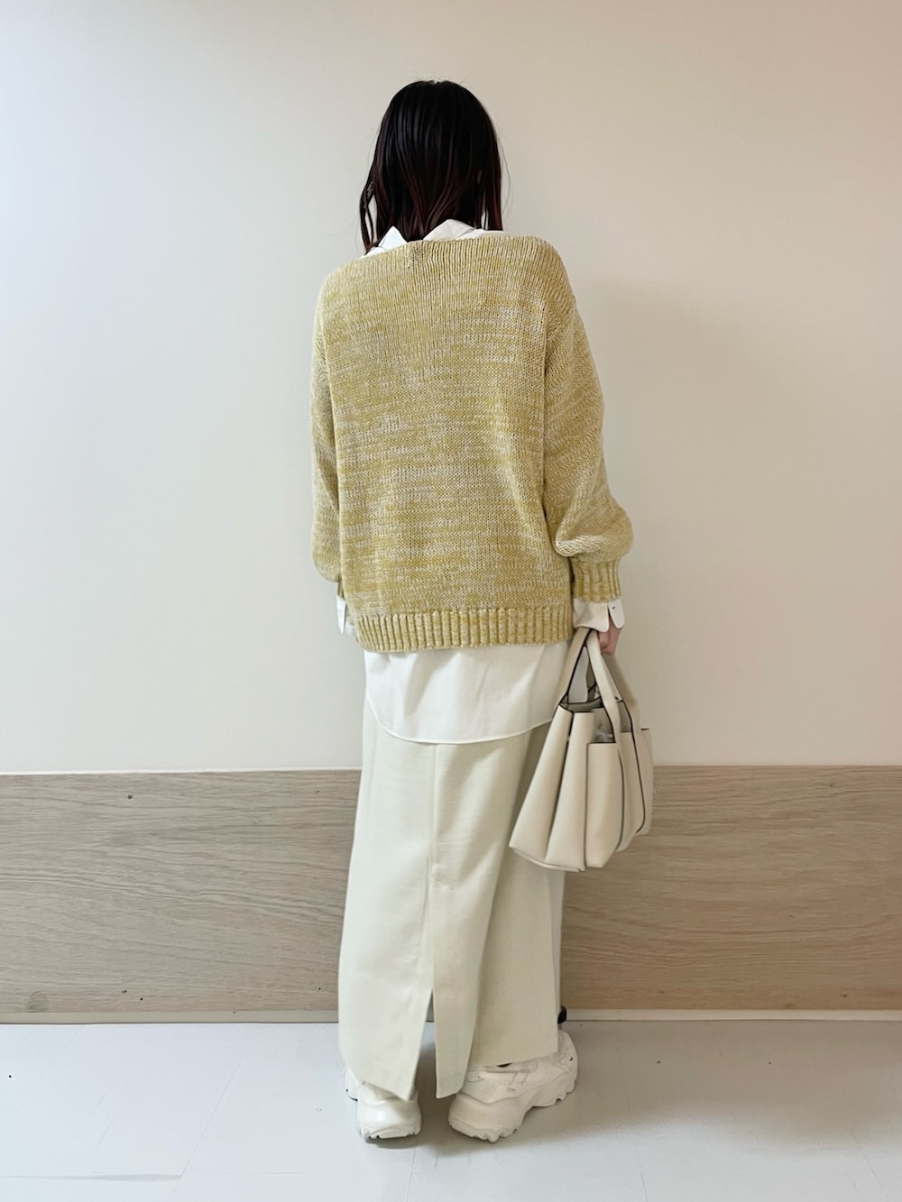 イエロー系のニット/セーター、ホワイト系のシャツ/ブラウス、ホワイト系のスカートを着用したレディースの春コーディネートの7枚目の写真