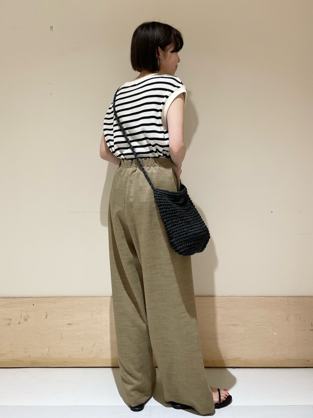 ベージュ系のその他パンツ、ブラック系のショルダーバッグ、ホワイト系のTシャツ/カットソーを着用したレディースの夏コーディネートの5枚目の写真