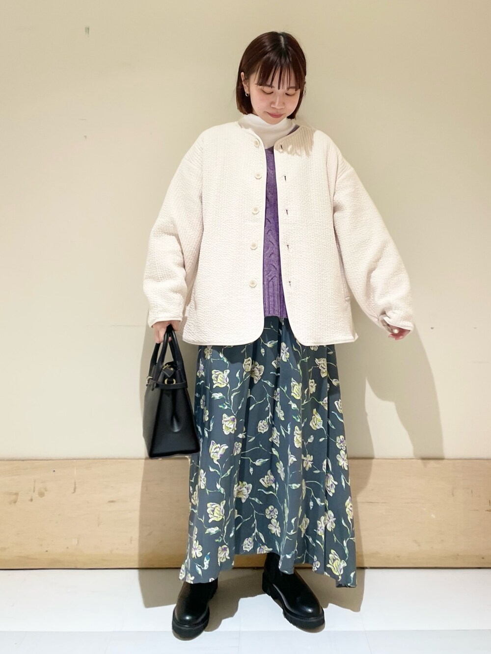 ホワイト系のTシャツ/カットソー、ホワイト系のノーカラージャケット、グレー系のスカートを着用したレディースの秋コーディネートの2枚目の写真