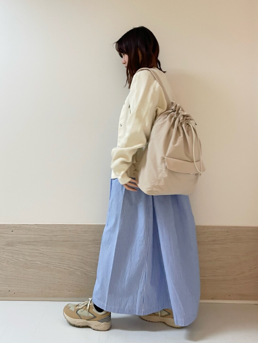 ホワイト系のカーディガン/ボレロ、ベージュ系のスニーカー、ブルー系のワンピースを着用したレディースの春コーディネートの4枚目の写真