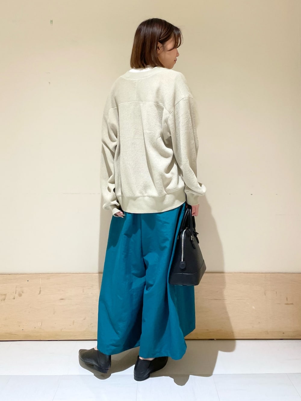 ベージュ系のカーディガン/ボレロ、ホワイト系のTシャツ/カットソー、ブラック系のショルダーバッグを着用したレディースの秋コーディネートの7枚目の写真