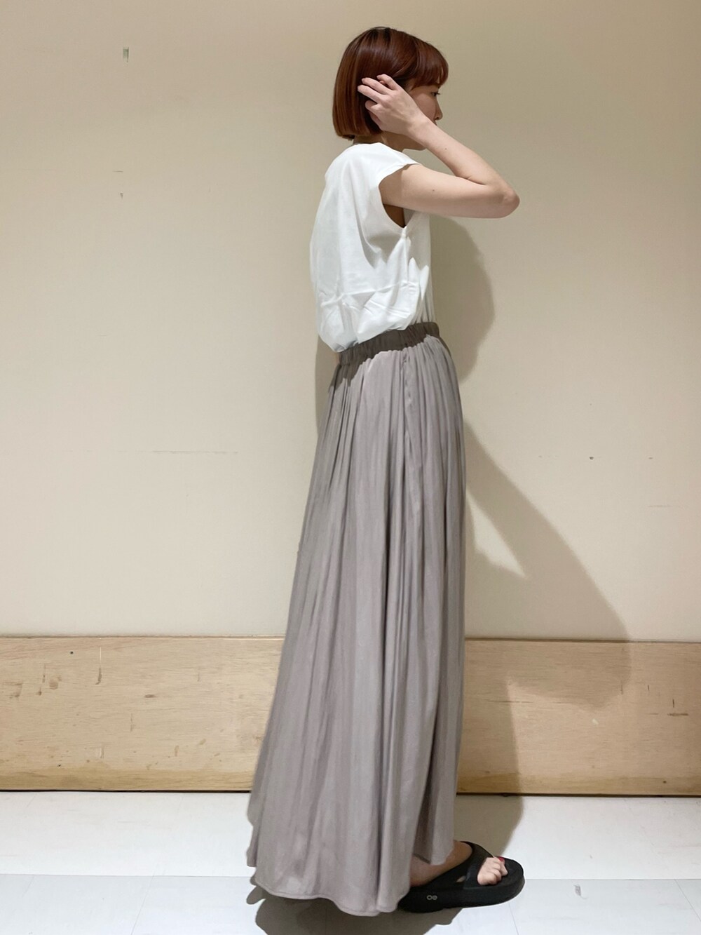 グレー系のスカート、ホワイト系のTシャツ/カットソー、ベージュ系のかごバッグを着用したレディースの春コーディネートの4枚目の写真