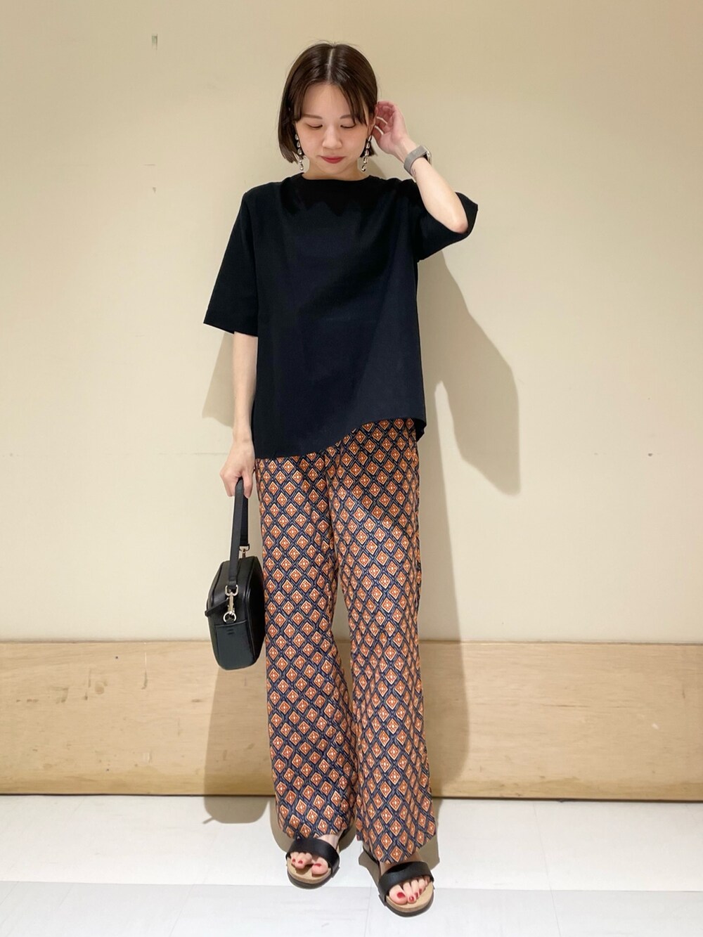 ブラック系のサンダル、ブラック系のショルダーバッグ、ブルー系のその他パンツを着用したレディースの夏コーディネートの2枚目の写真