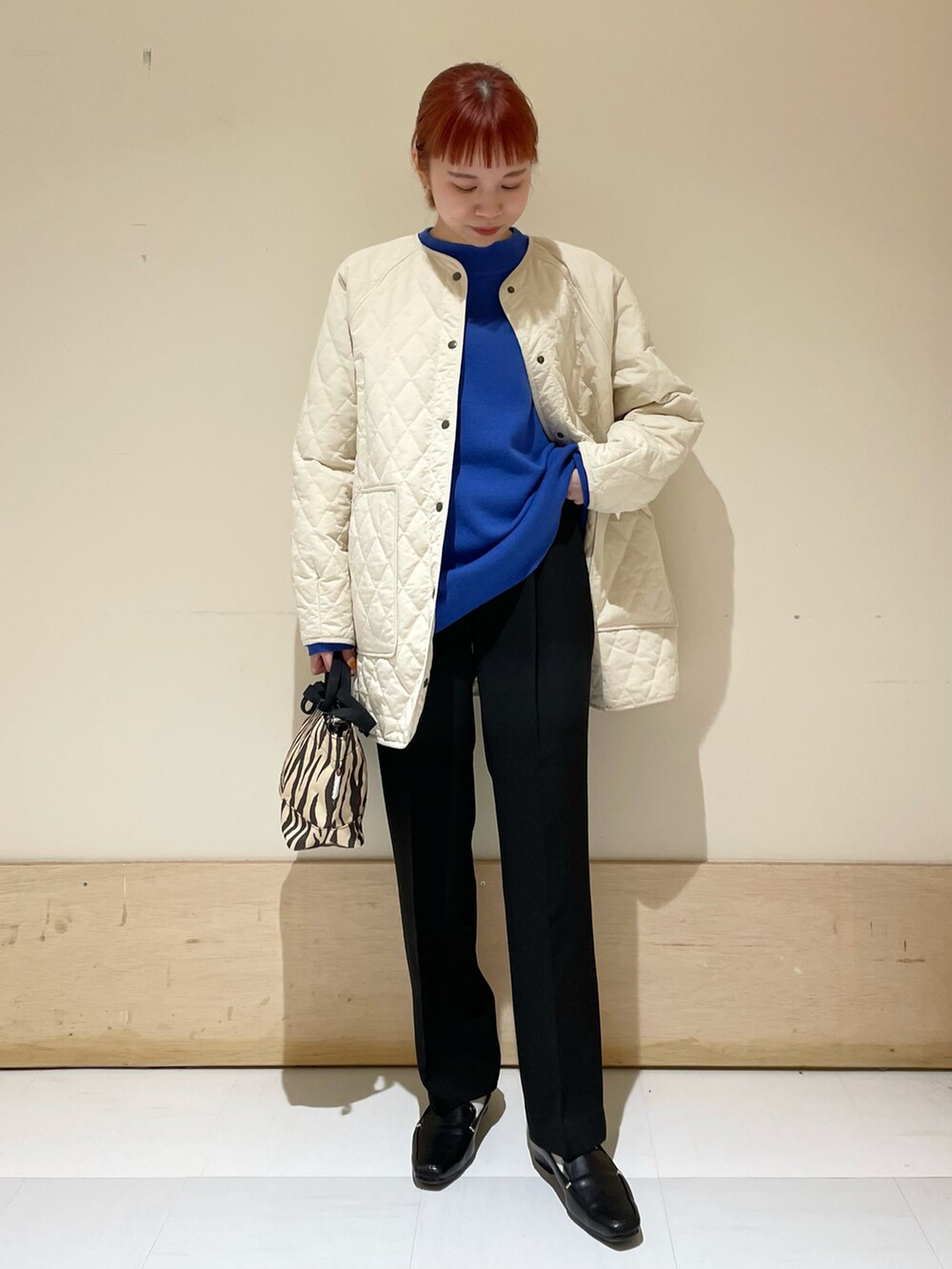 ブラック系のその他パンツ、ホワイト系のダウンジャケット/コート、ブルー系のニット/セーターを着用したレディースの冬コーディネートの2枚目の写真