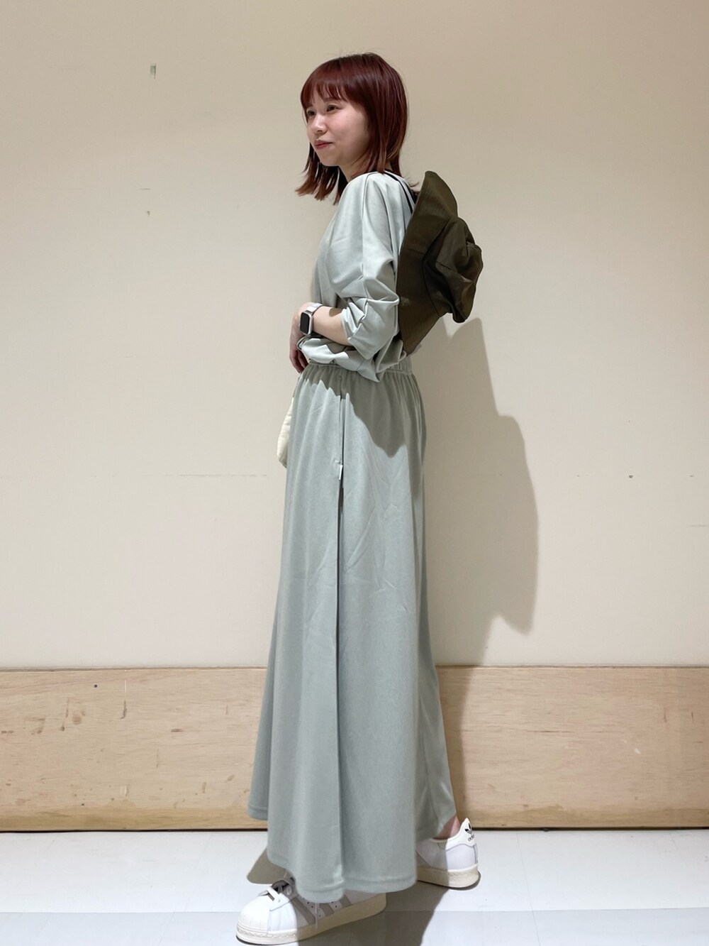 ホワイト系のスニーカー、グリーン系のスカート、グリーン系のTシャツ/カットソーを着用したレディースの春コーディネートの3枚目の写真