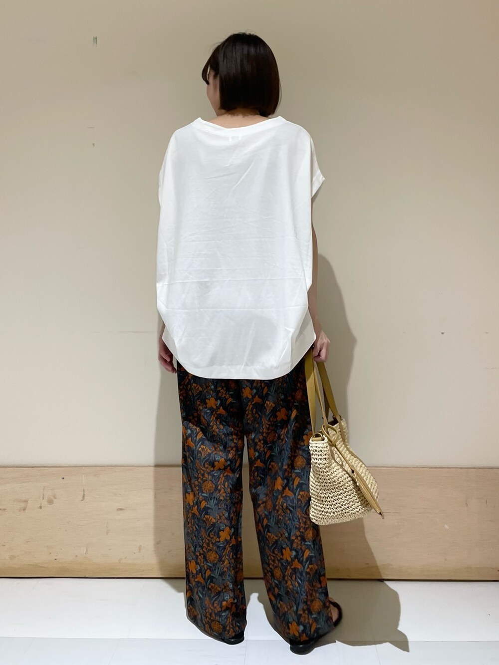 オレンジ系のその他パンツ、ホワイト系のTシャツ/カットソー、ベージュ系のトートバッグを着用したレディースの夏コーディネートの6枚目の写真