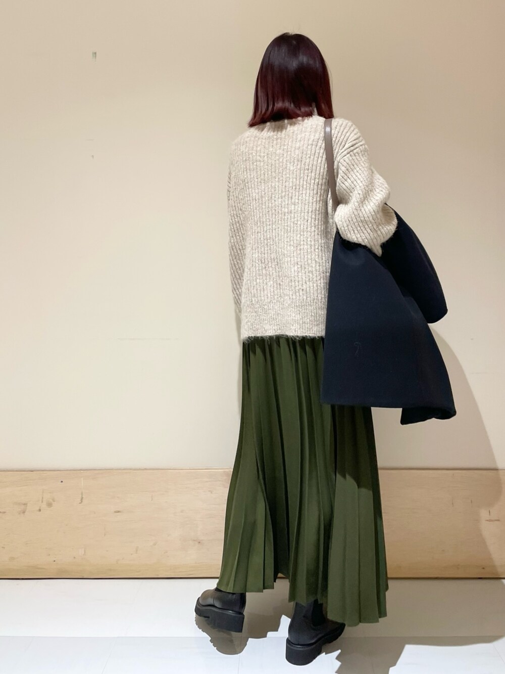 ブラック系のその他アウター、ブラック系のブーツ、グリーン系のスカートを着用したレディースの冬コーディネートの10枚目の写真