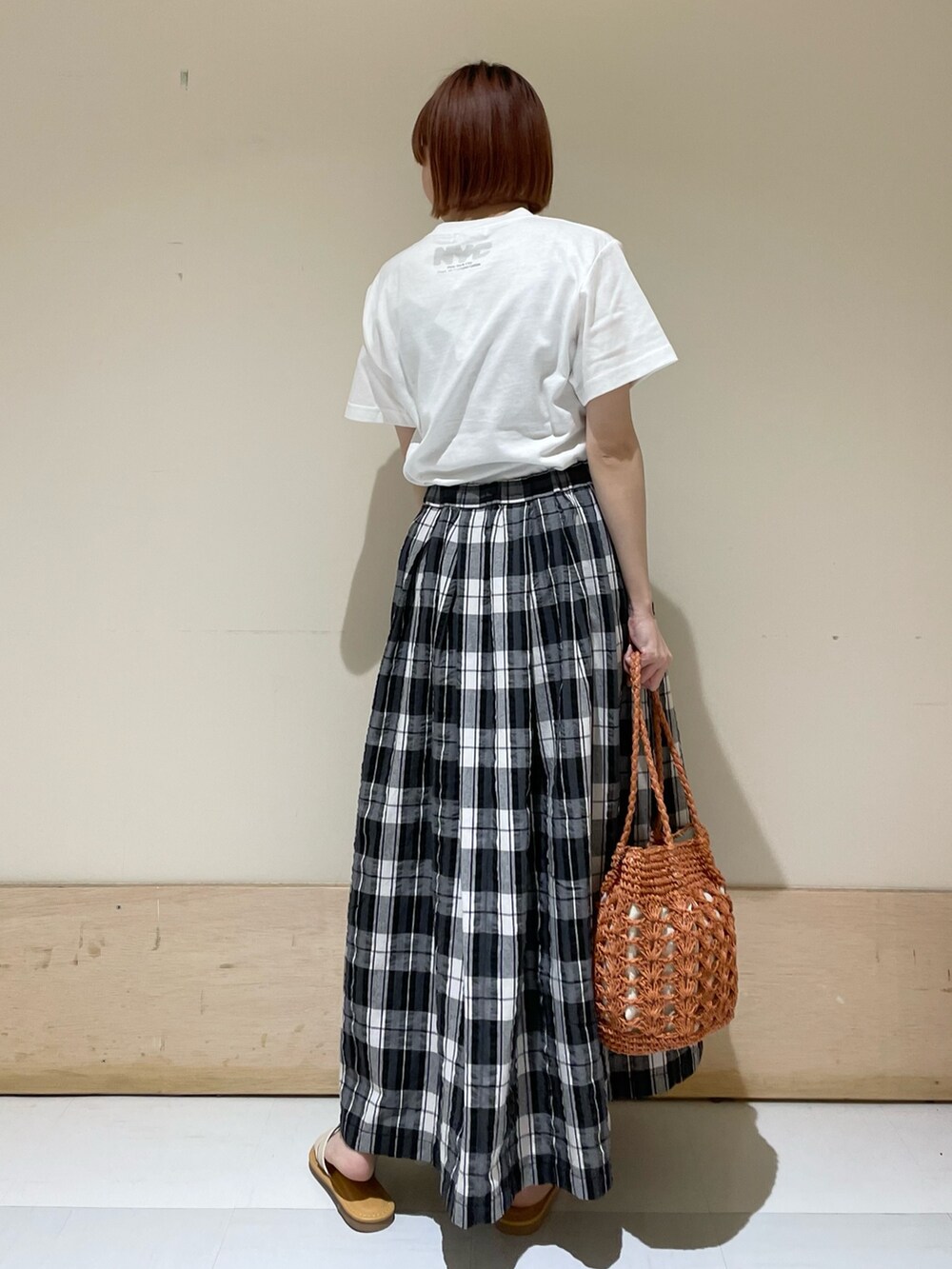 ブラック系のスカート、グレー系のTシャツ/カットソー、ブラウン系のかごバッグを着用したレディースの春コーディネートの8枚目の写真