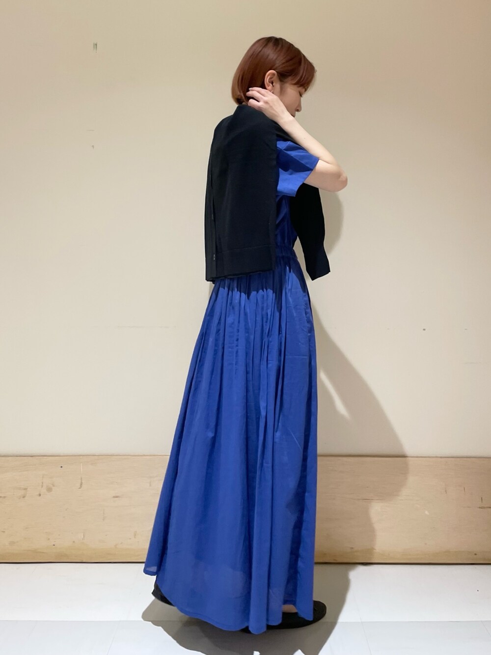 ブルー系のワンピース、ブラック系のカーディガン/ボレロ、ホワイト系のトートバッグを着用したレディースの春コーディネートの7枚目の写真