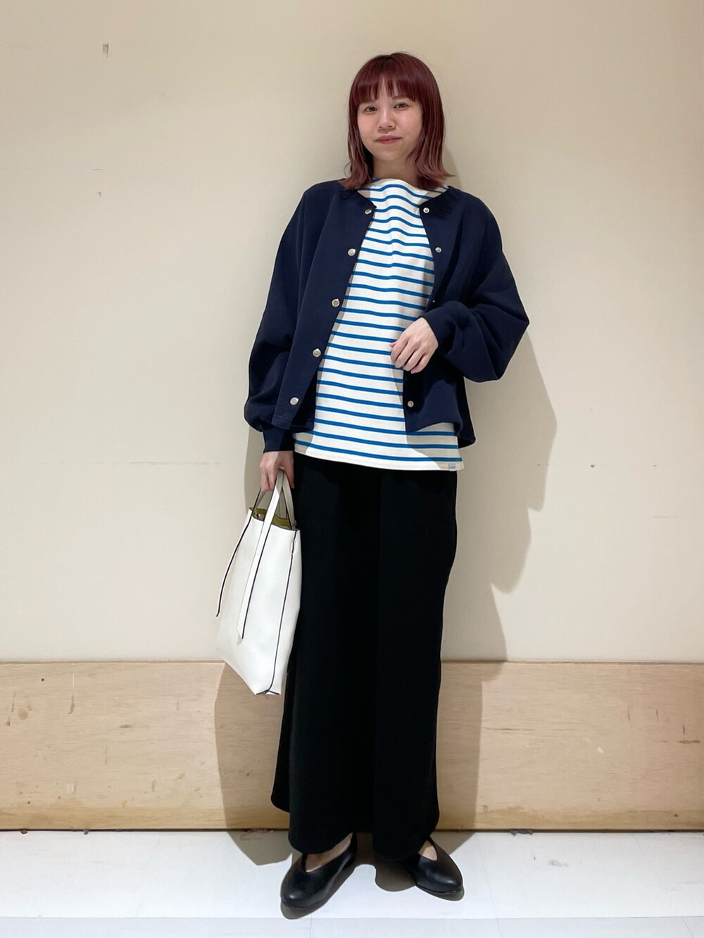 ブルー系のニット/セーター、ブルー系のTシャツ/カットソー、ブラック系のパンプスを着用したレディースの春コーディネートの2枚目の写真