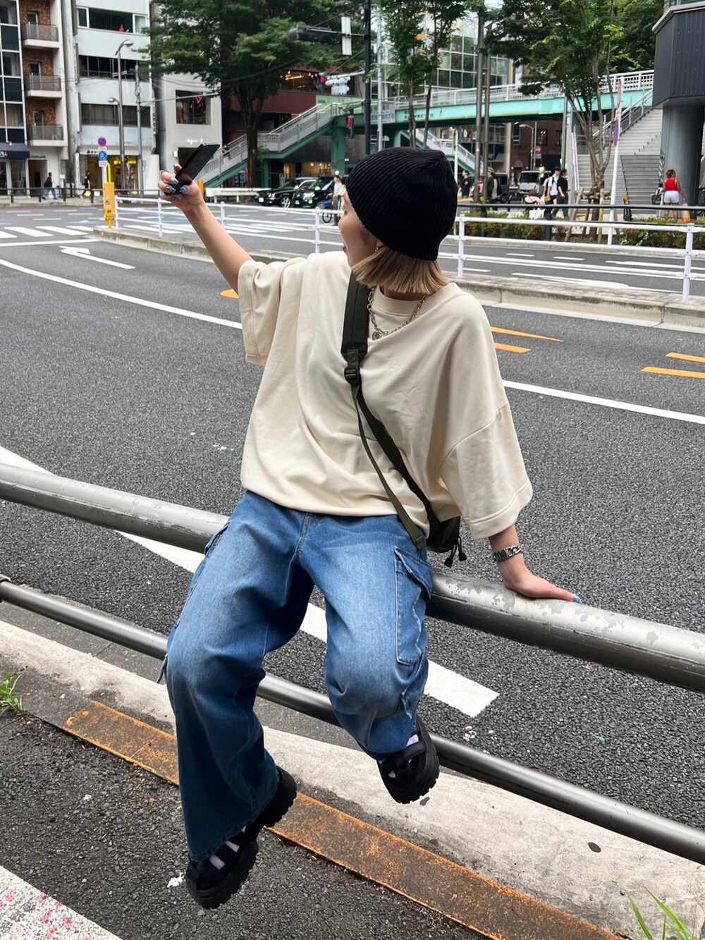 ブルー系のデニムパンツ、ベージュ系のスウェット、ブラック系のサンダルを着用したレディースの夏コーディネートの3枚目の写真