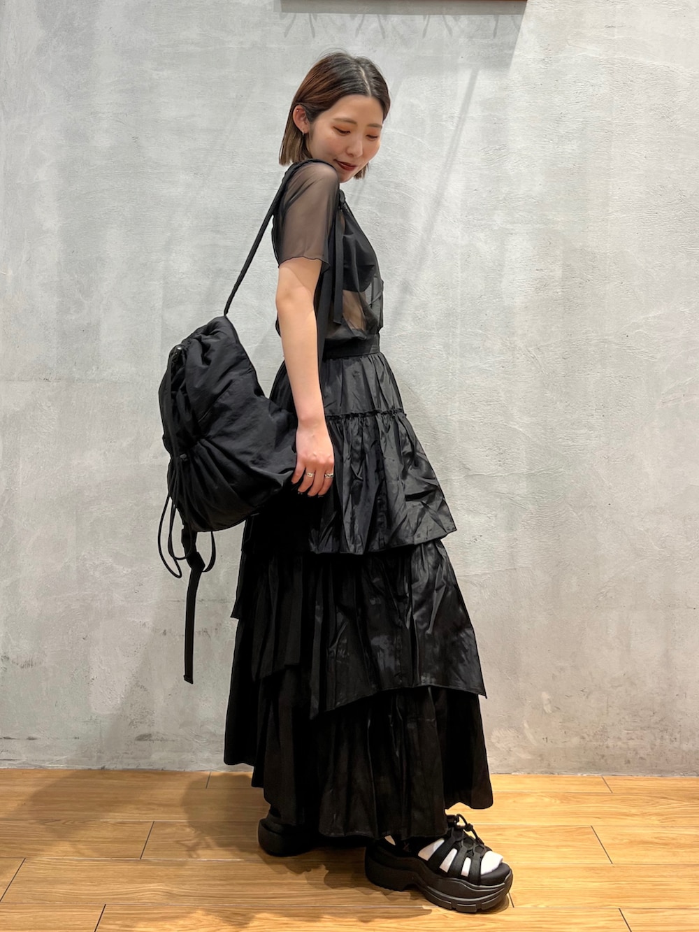 ブラック系のスカート、ブラック系のTシャツ/カットソー、ブラック系のバックパック/リュックを着用したレディースの夏コーディネートの3枚目の写真