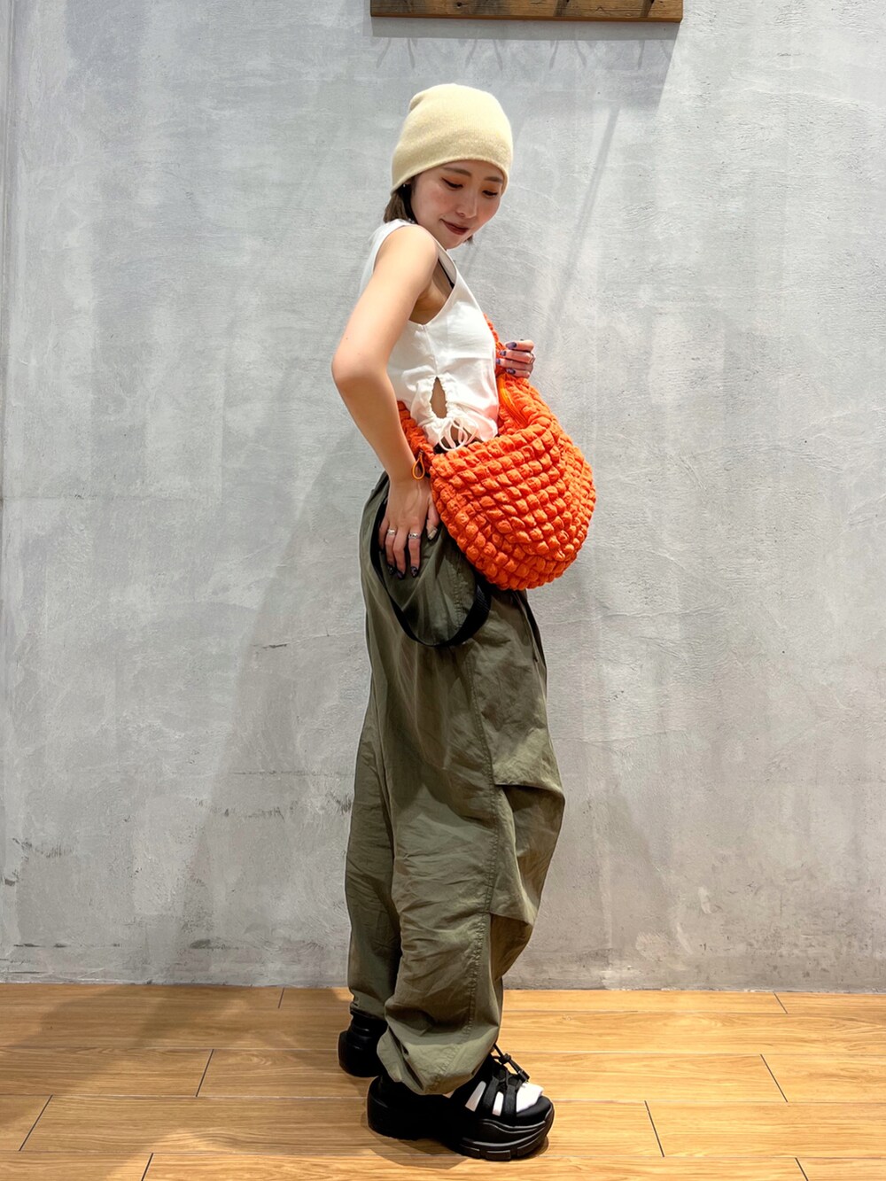 グリーン系のその他パンツ、ホワイト系のTシャツ/カットソー、オレンジ系のショルダーバッグを着用したレディースの夏コーディネートの3枚目の写真
