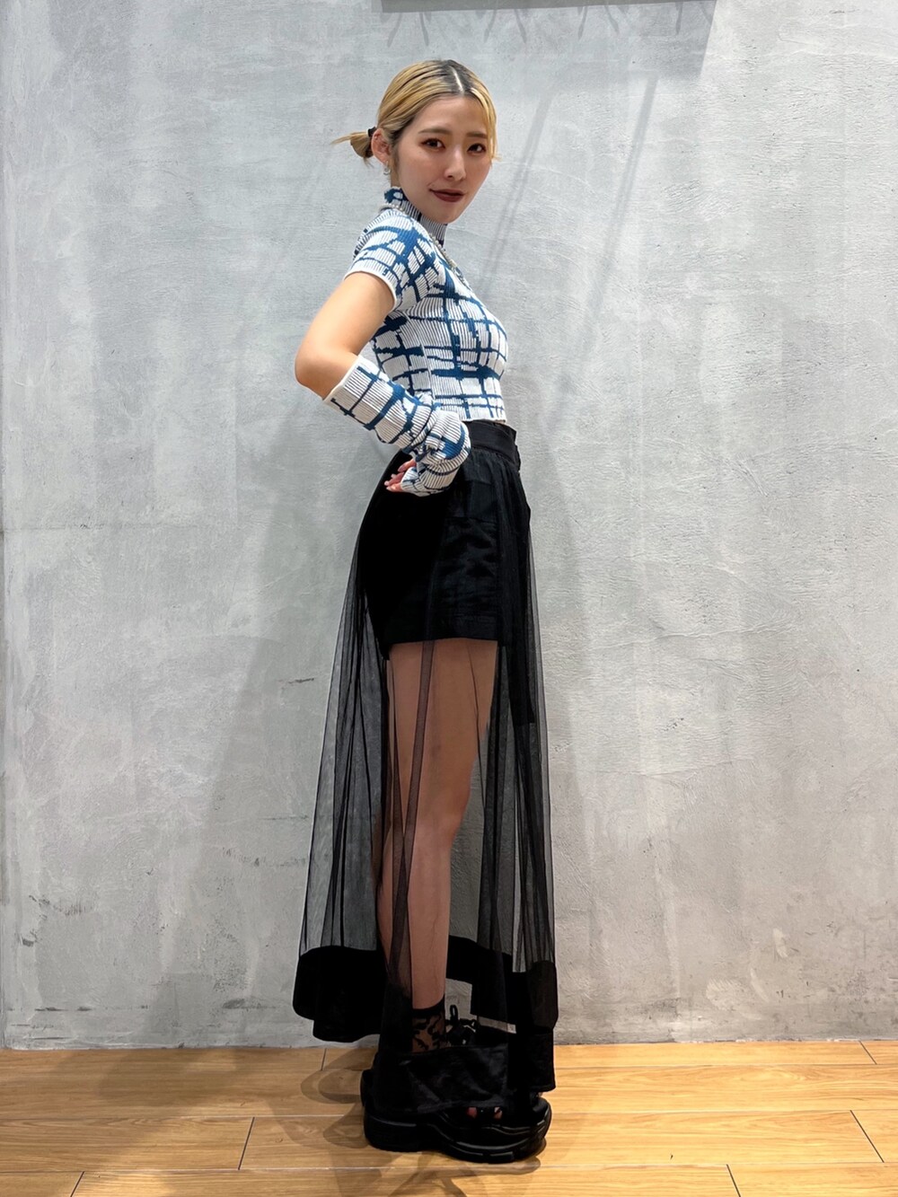 ブラック系のスカート、ホワイト系のトップスを着用したレディースの秋コーディネートの3枚目の写真