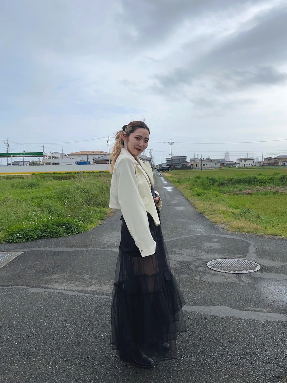 ホワイト系のテーラードジャケット、ブラック系のスカート、ブラック系のスカートを着用したレディースの春コーディネートの4枚目の写真