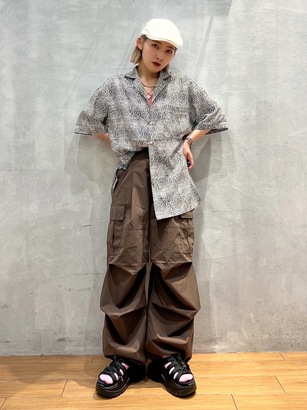 ブラウン系のスラックス、ピンク系のタンクトップ、ホワイト系のシャツ/ブラウスを着用したレディースの夏コーディネートの2枚目の写真