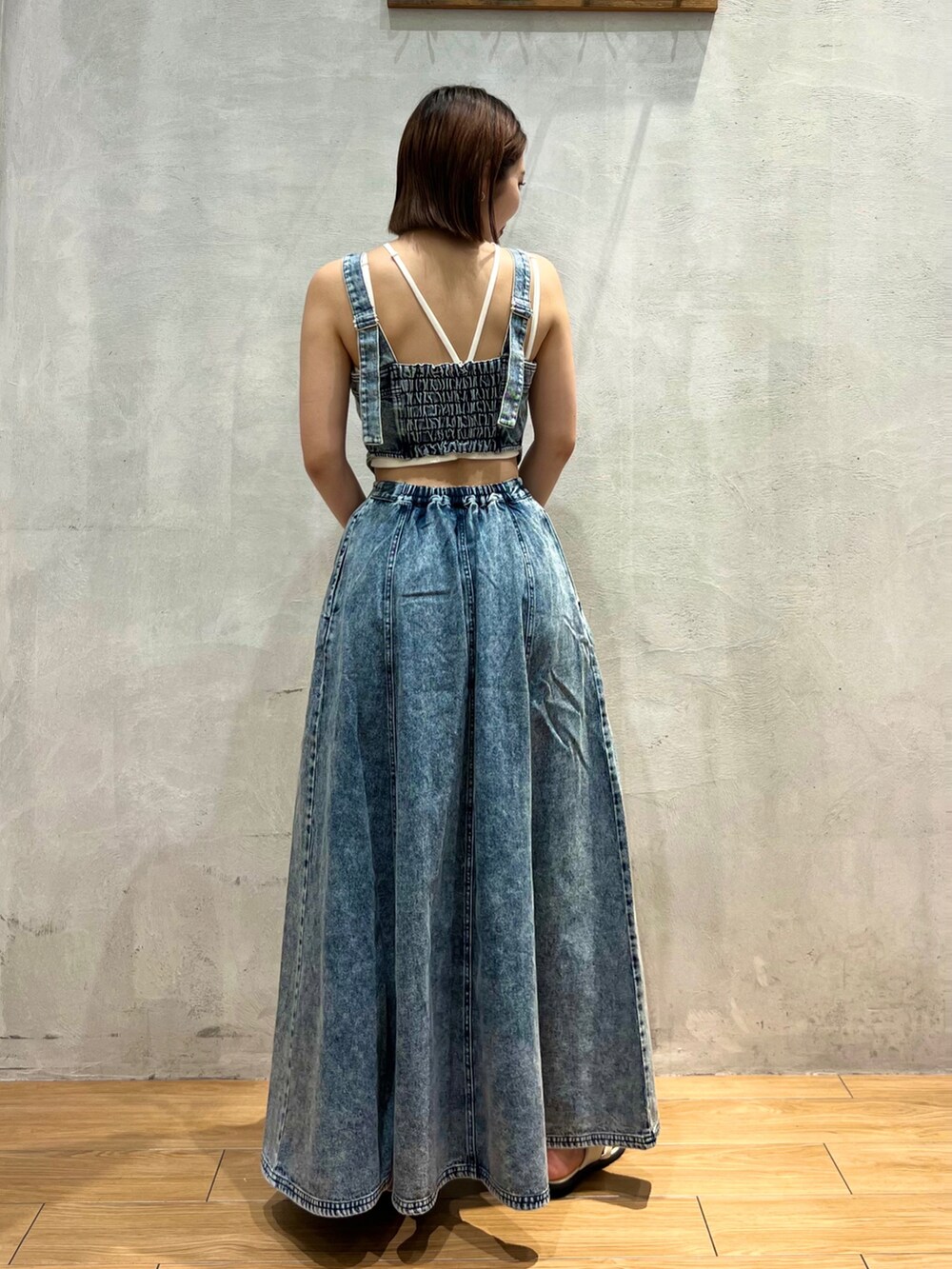 ホワイト系のショルダーバッグ、ブルー系のジャンパースカート、ホワイト系のサンダルを着用したレディースの夏コーディネートの4枚目の写真