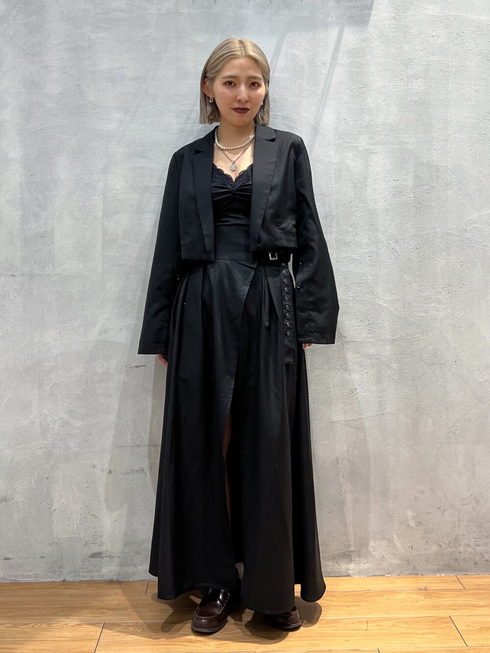 ブラック系のテーラードジャケット、ブラック系のスカートを着用したレディースの秋コーディネートの2枚目の写真