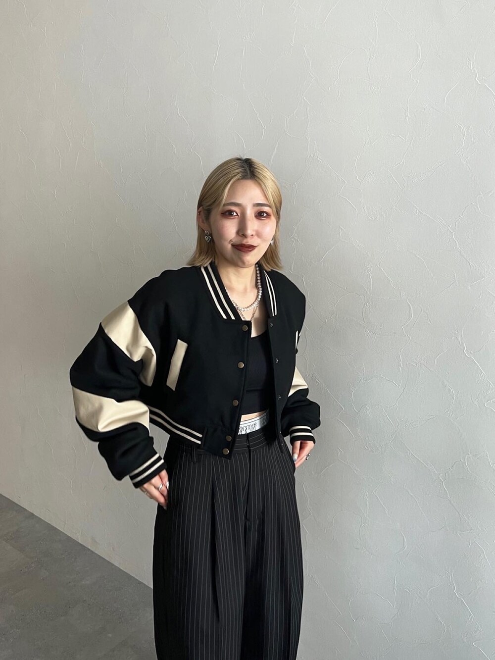 ブラック系のスラックス、ブラック系のスタジャンを着用したレディースの秋コーディネートの4枚目の写真