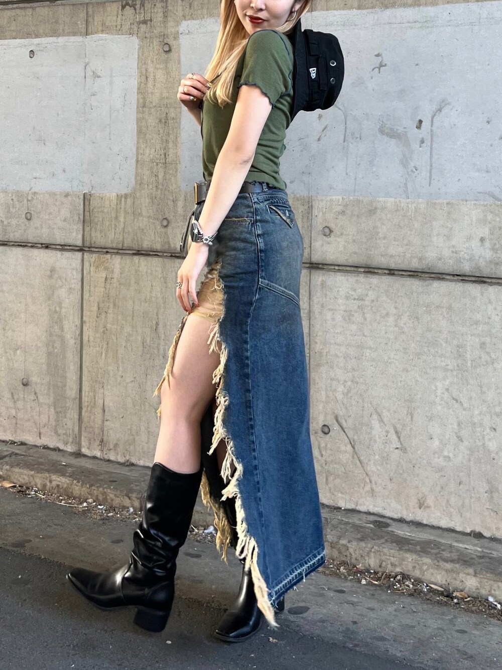 グリーン系のTシャツ/カットソー、ブルー系のデニムスカート、ブルー系のショルダーバッグを着用したレディースの春コーディネートの4枚目の写真