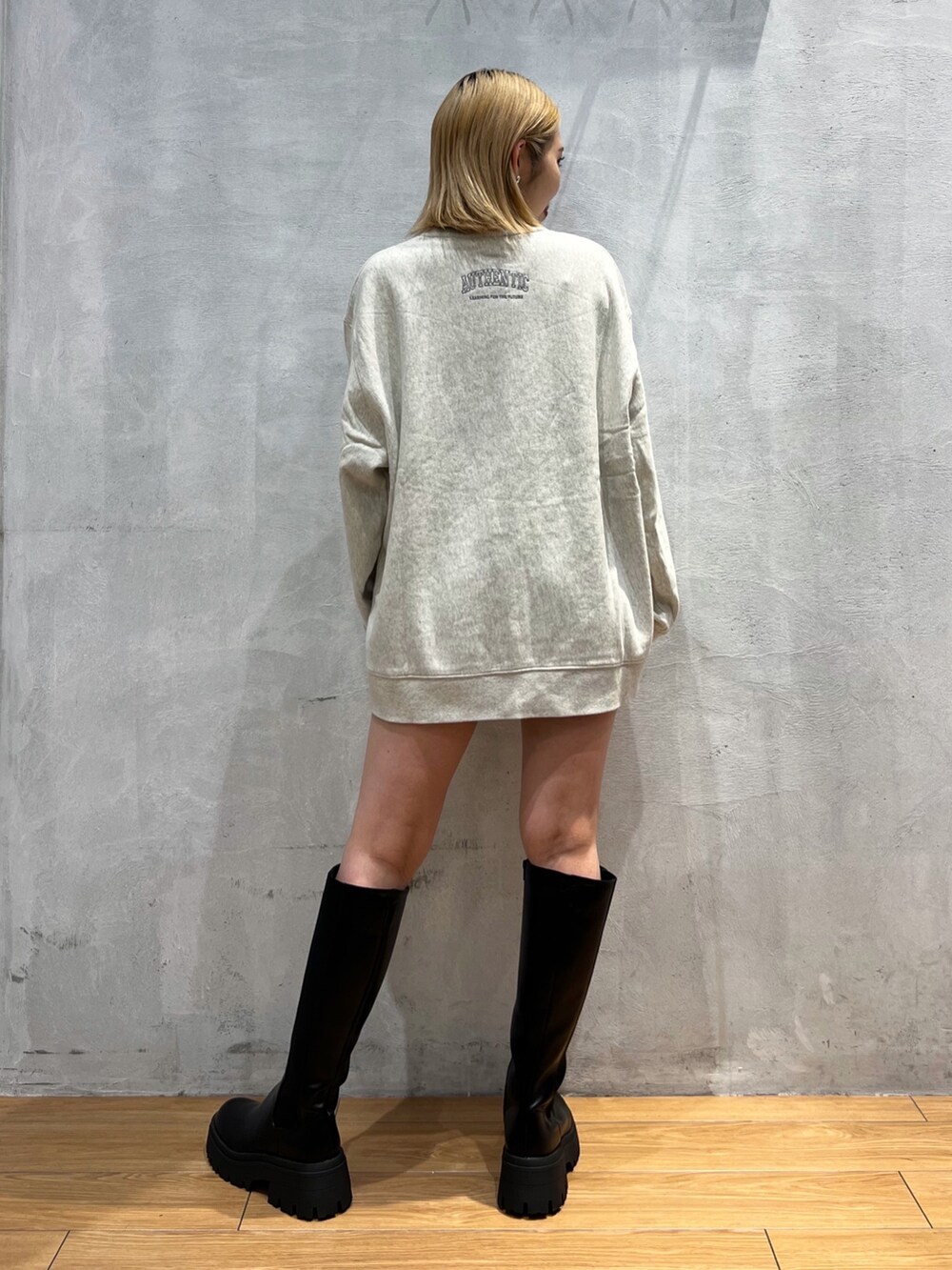 ベージュ系のスウェット、ブラック系のブーツ、ブラック系のパンツを着用したレディースの秋コーディネートの4枚目の写真